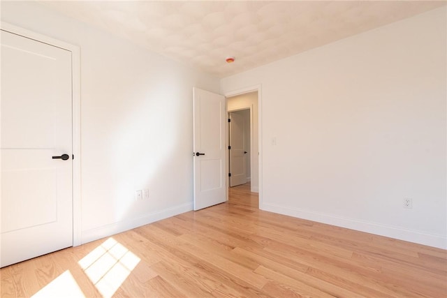 unfurnished bedroom featuring baseboards and light wood-type flooring