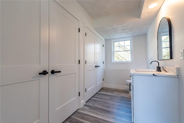laundry room featuring baseboards, light wood-type flooring, and a sink