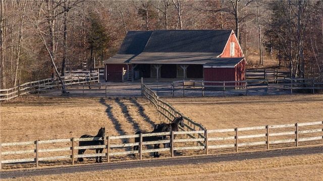 view of front facade with an outdoor structure, a rural view, and an exterior structure