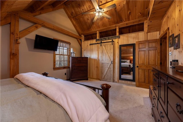 bedroom featuring a barn door, vaulted ceiling with beams, wood walls, and light carpet