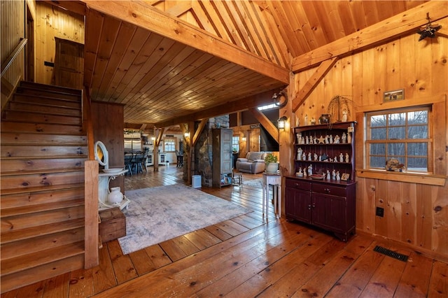 interior space featuring stairs, wooden walls, visible vents, and wood-type flooring