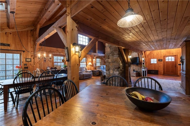 dining area with wood walls, a healthy amount of sunlight, and hardwood / wood-style flooring