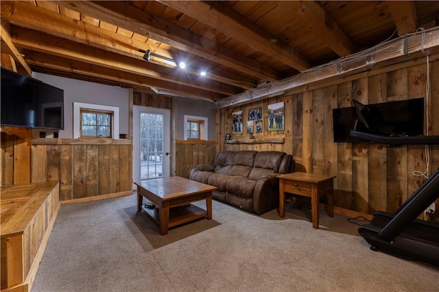 living area with beamed ceiling, wood ceiling, wood walls, and carpet flooring