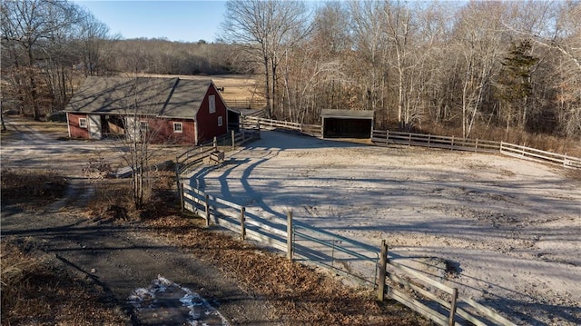 view of street with a barn, a rural view, a forest view, and an exterior structure