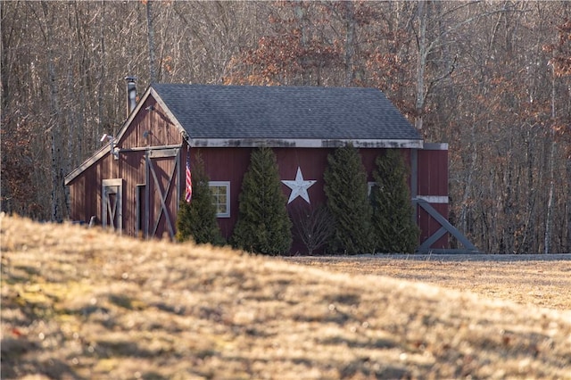 view of barn featuring a view of trees