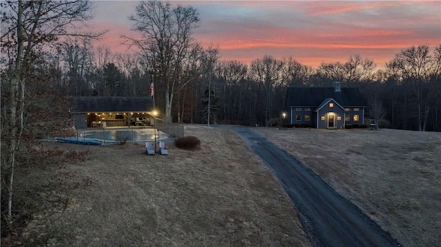 view of road featuring a wooded view and driveway