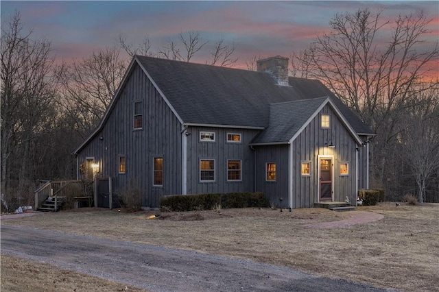 view of front of property with board and batten siding, a chimney, and a shingled roof