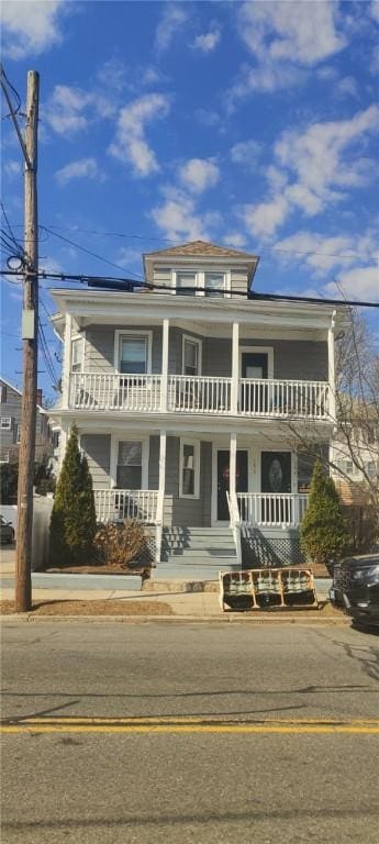 traditional style home featuring a balcony and covered porch