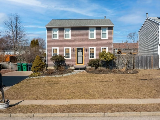 view of front of home with a front lawn and fence