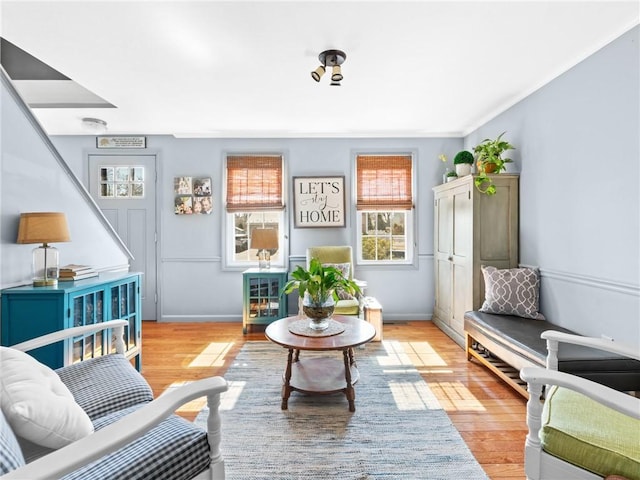 living area featuring baseboards and light wood finished floors