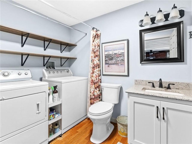 full bath featuring toilet, a shower with curtain, wood finished floors, independent washer and dryer, and vanity