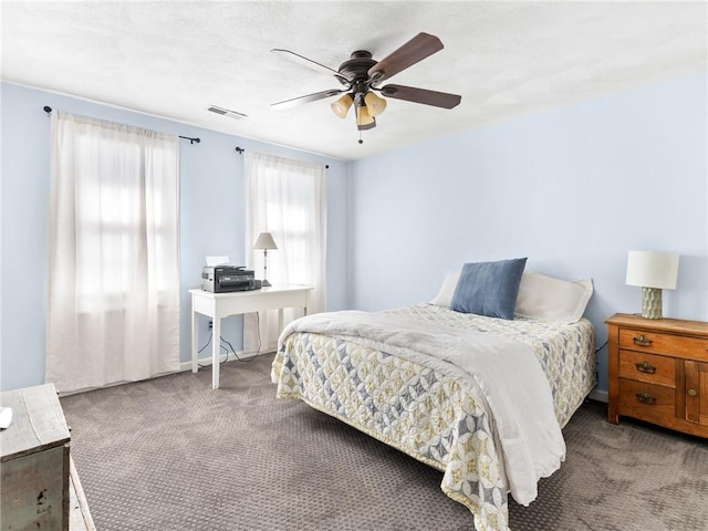 carpeted bedroom with visible vents and a ceiling fan