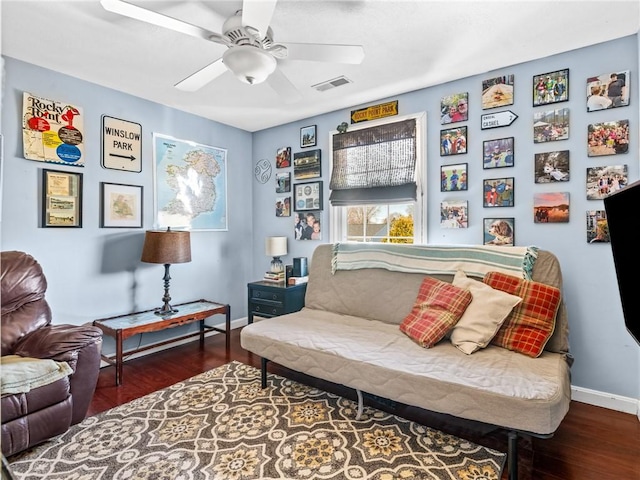 living area featuring a ceiling fan, wood finished floors, visible vents, and baseboards