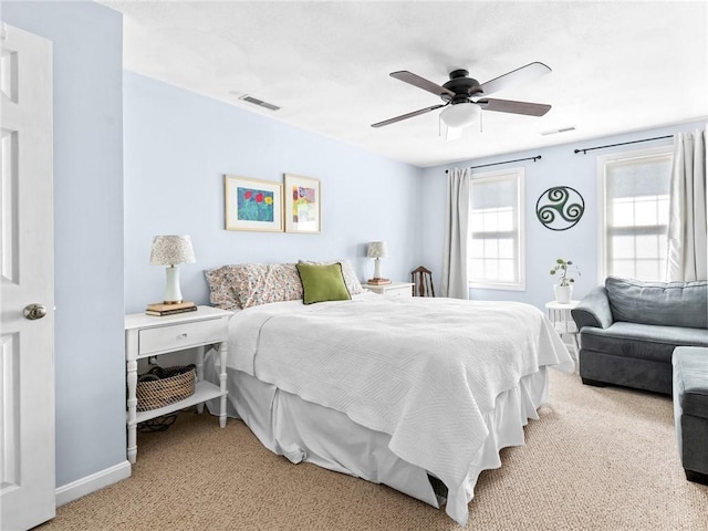 bedroom featuring visible vents, light carpet, baseboards, and a ceiling fan