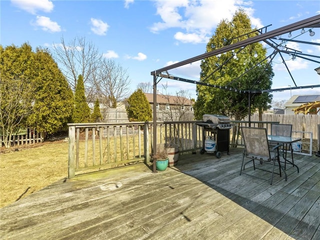 deck with area for grilling, outdoor dining area, and a fenced backyard