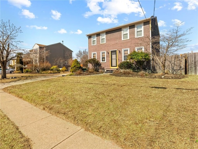 colonial inspired home featuring a front yard and fence