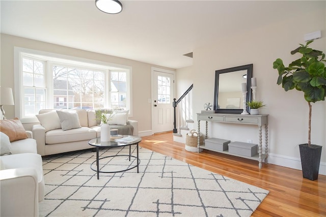 living room with stairway, baseboards, and wood finished floors