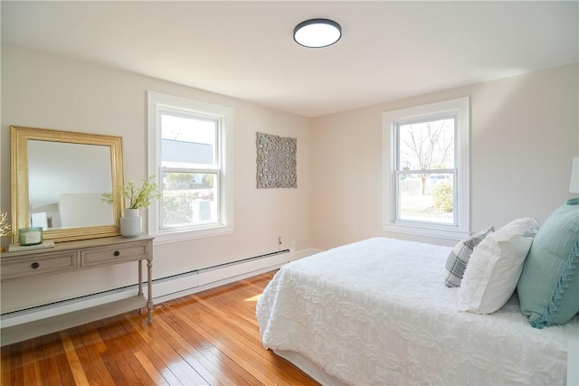 bedroom with hardwood / wood-style flooring and a baseboard radiator