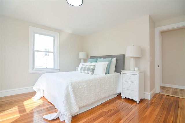 bedroom with light wood finished floors and baseboards