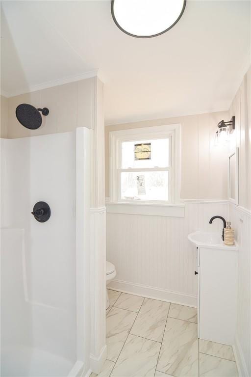 bathroom featuring walk in shower, toilet, marble finish floor, and vanity