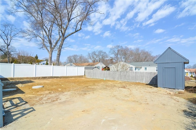 view of yard featuring an outbuilding, a fenced backyard, and a shed