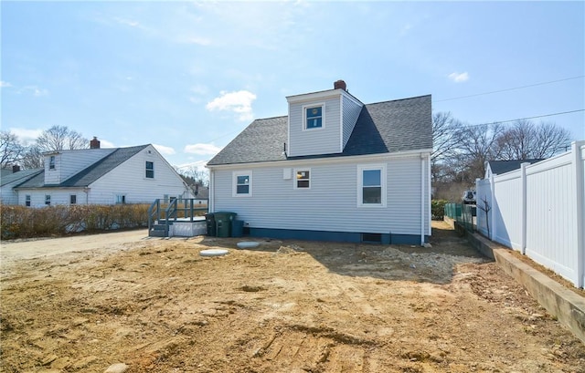 back of house with roof with shingles and fence