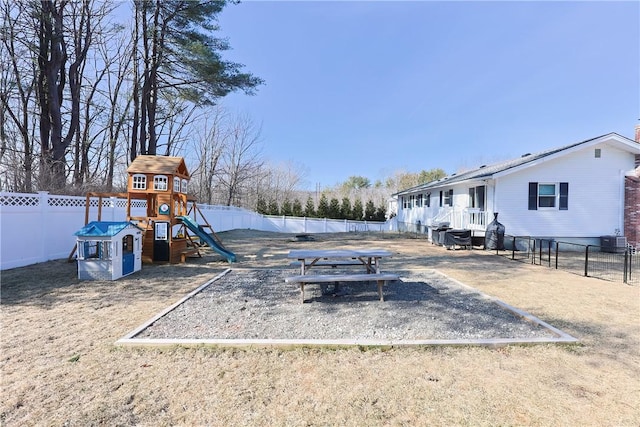 view of yard with central AC, a fenced backyard, and a playground