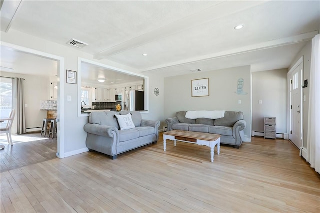 living room with light wood finished floors, visible vents, recessed lighting, and beam ceiling