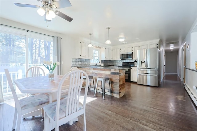 dining area featuring ceiling fan, visible vents, dark wood-style flooring, and a baseboard radiator