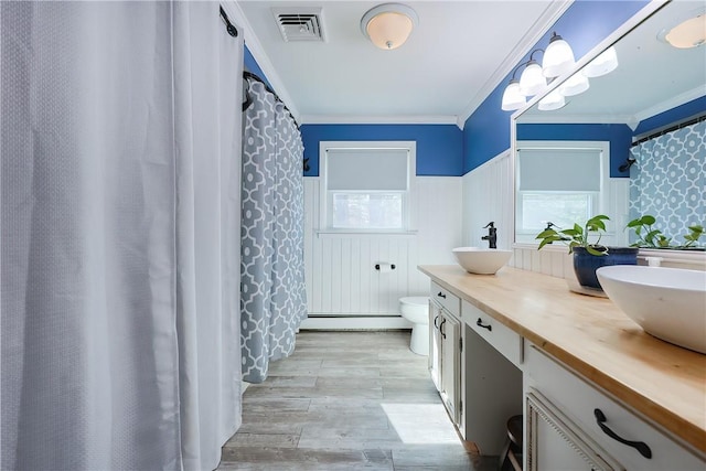 full bath with a sink, visible vents, wood finished floors, and ornamental molding