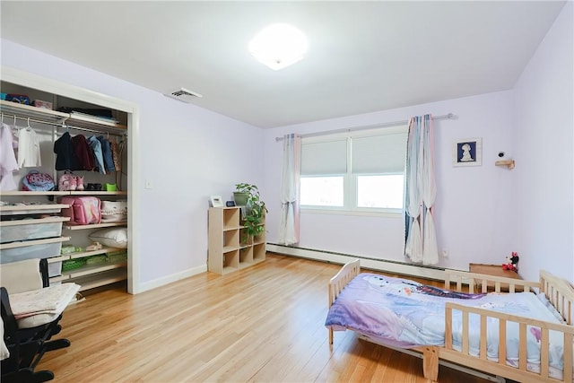 bedroom featuring a closet, visible vents, baseboards, and wood finished floors