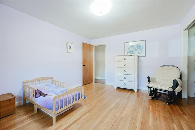 bedroom with baseboards and light wood-type flooring