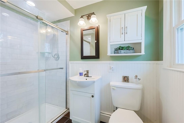 bathroom featuring a wainscoted wall, a stall shower, and vanity