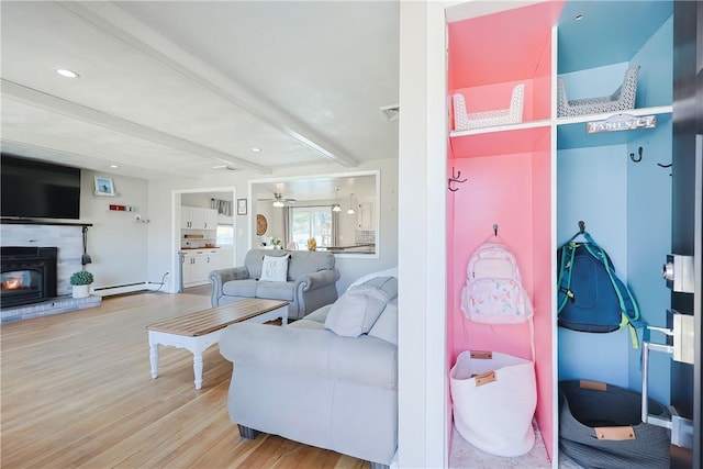 living area featuring a baseboard heating unit, ceiling fan, beam ceiling, recessed lighting, and wood finished floors