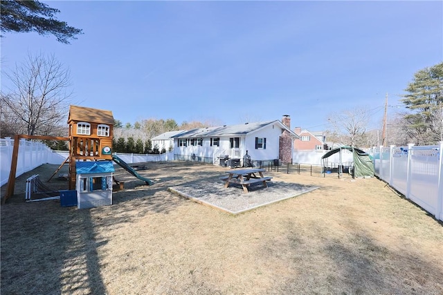 exterior space with a playground and a fenced backyard