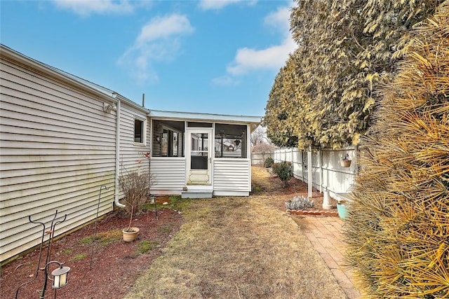 exterior space with a sunroom and fence