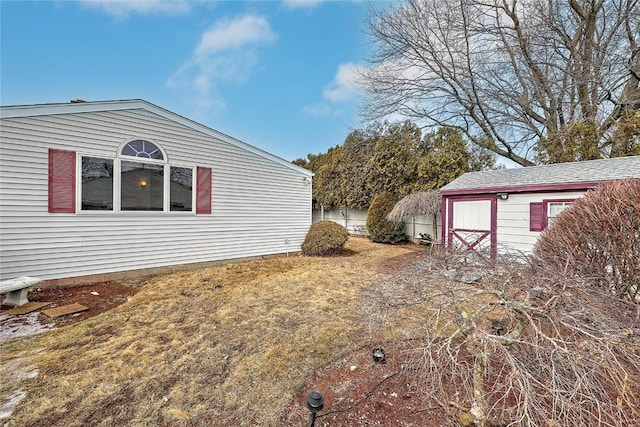 view of side of home with an outdoor structure and a yard