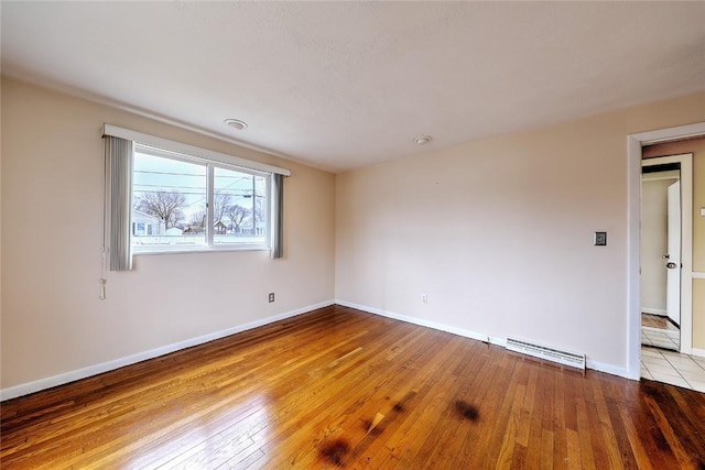 empty room featuring visible vents, baseboards, and hardwood / wood-style floors