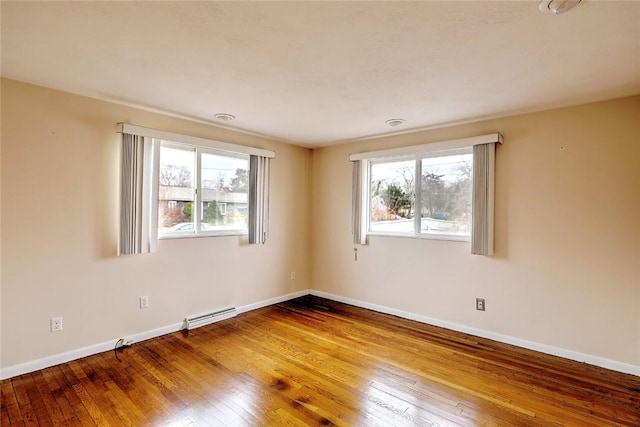 unfurnished room with hardwood / wood-style floors and baseboards