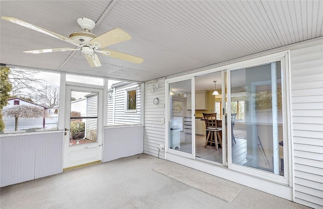 unfurnished sunroom featuring ceiling fan