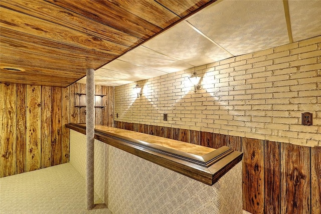 interior space featuring wooden walls, carpet flooring, and wood ceiling