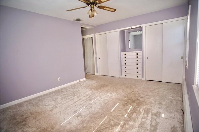 unfurnished bedroom with baseboards, visible vents, multiple closets, and carpet floors