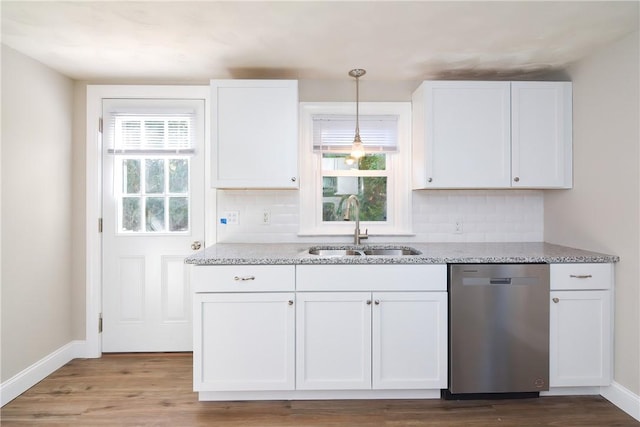 kitchen with a wealth of natural light, a sink, light stone countertops, and stainless steel dishwasher