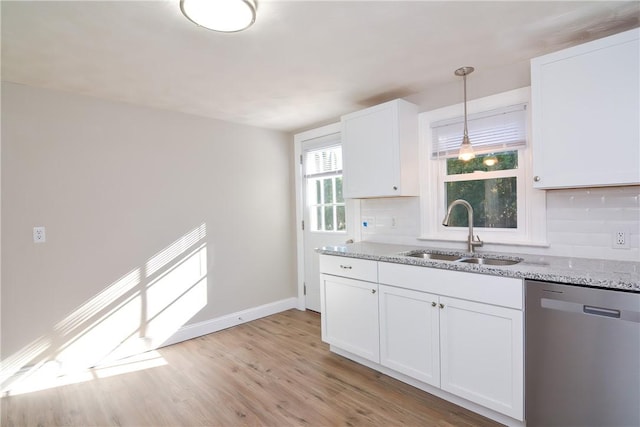 kitchen with tasteful backsplash, a sink, light stone countertops, and stainless steel dishwasher