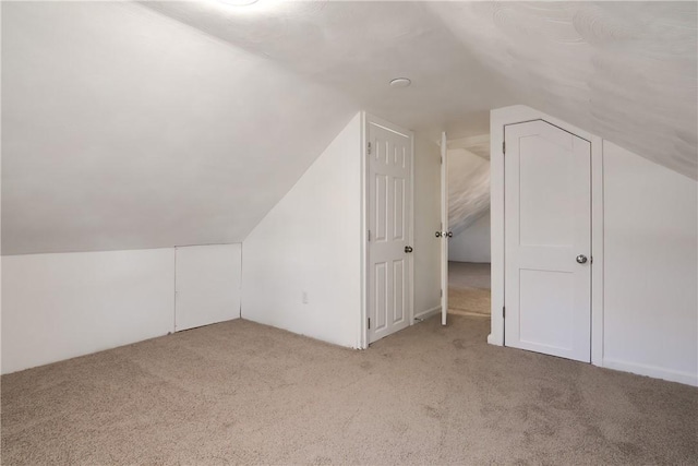 bonus room with light carpet and lofted ceiling