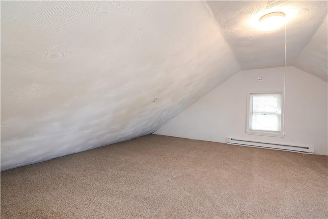 additional living space featuring vaulted ceiling, carpet floors, and a baseboard radiator