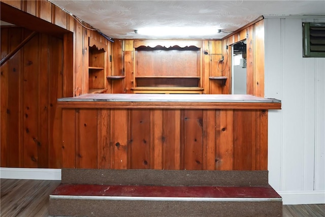 bar featuring wood walls and wood finished floors