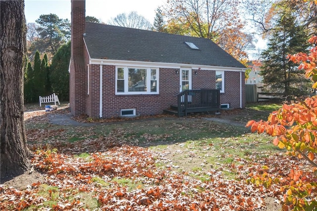 rear view of house featuring fence, a shingled roof, a chimney, a lawn, and brick siding