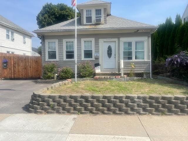 bungalow-style house featuring entry steps, roof with shingles, and fence