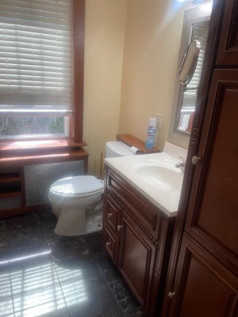 bathroom featuring radiator, toilet, and vanity